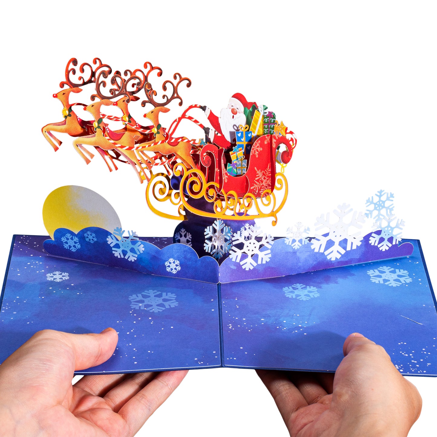 Hands holding Santa Sleigh Christmas pop-up card with intricate 3D design.