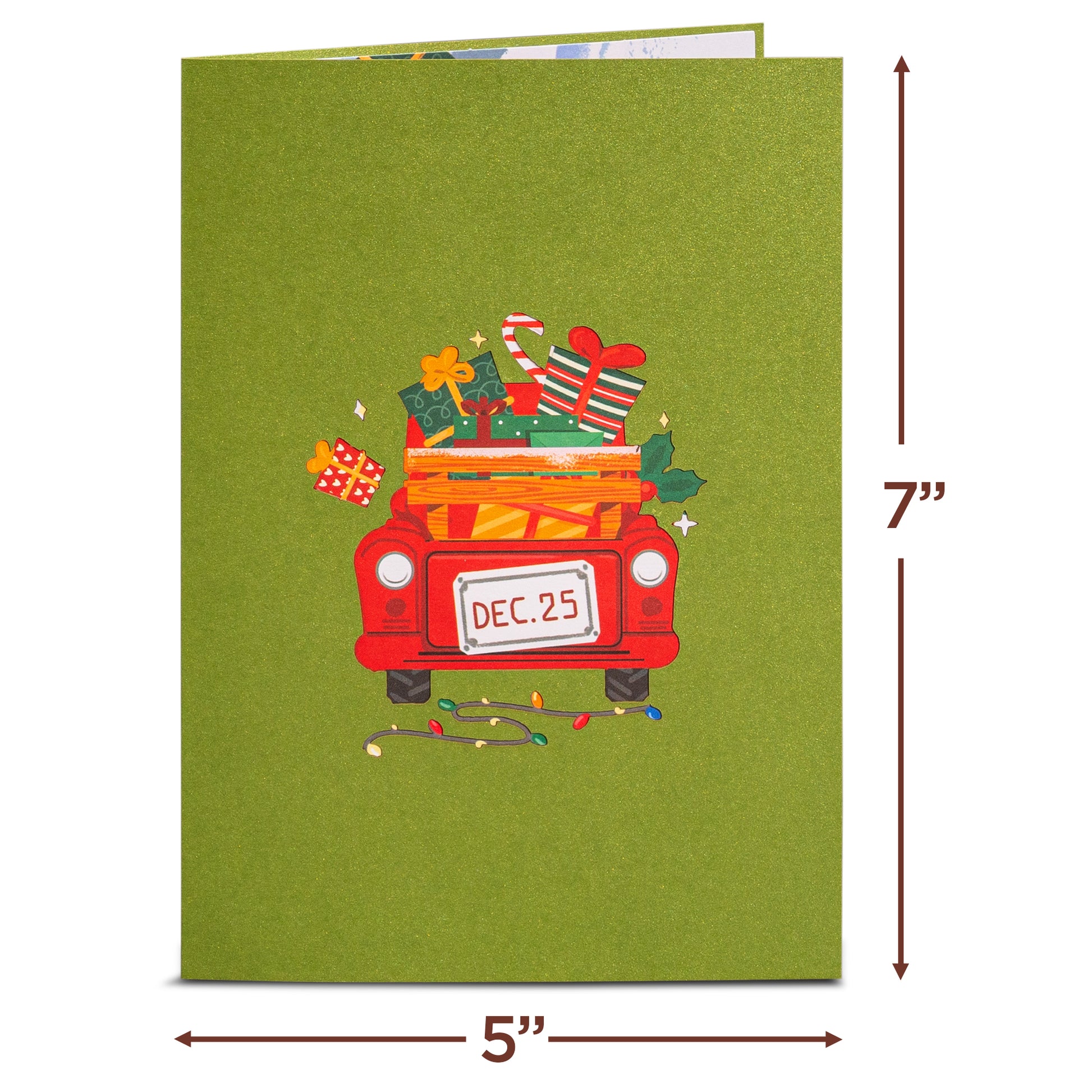 Green Christmas card cover with a red truck carrying gifts and a 'Dec. 25' license plate.