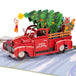Christmas pop-up card showcasing a red truck with a tree and holiday gifts.
