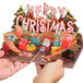 Hands holding a Merry Christmas pop-up card with vibrant holiday design.