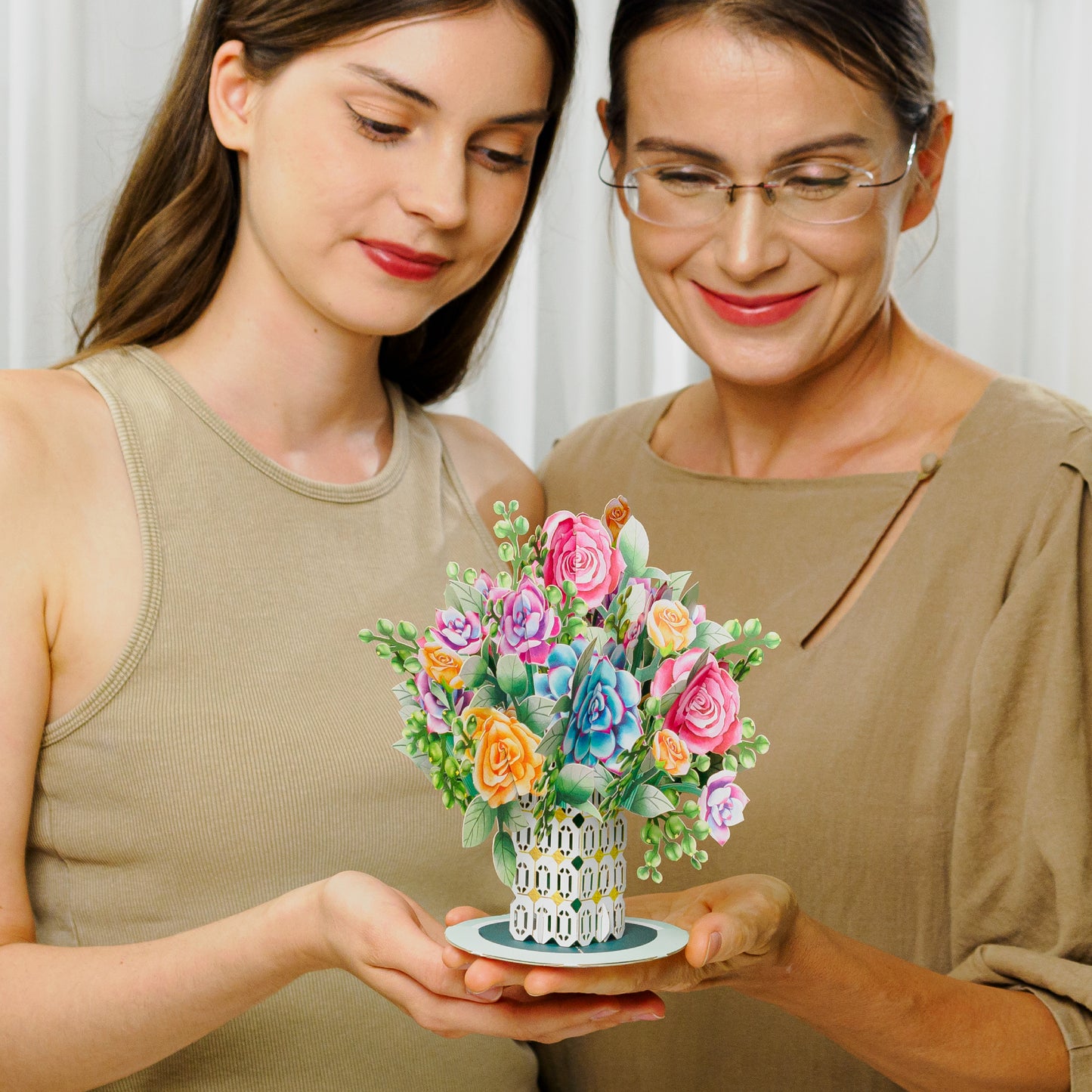 Two people admiring a roses and succulent oversized pop-up card centerpiece.