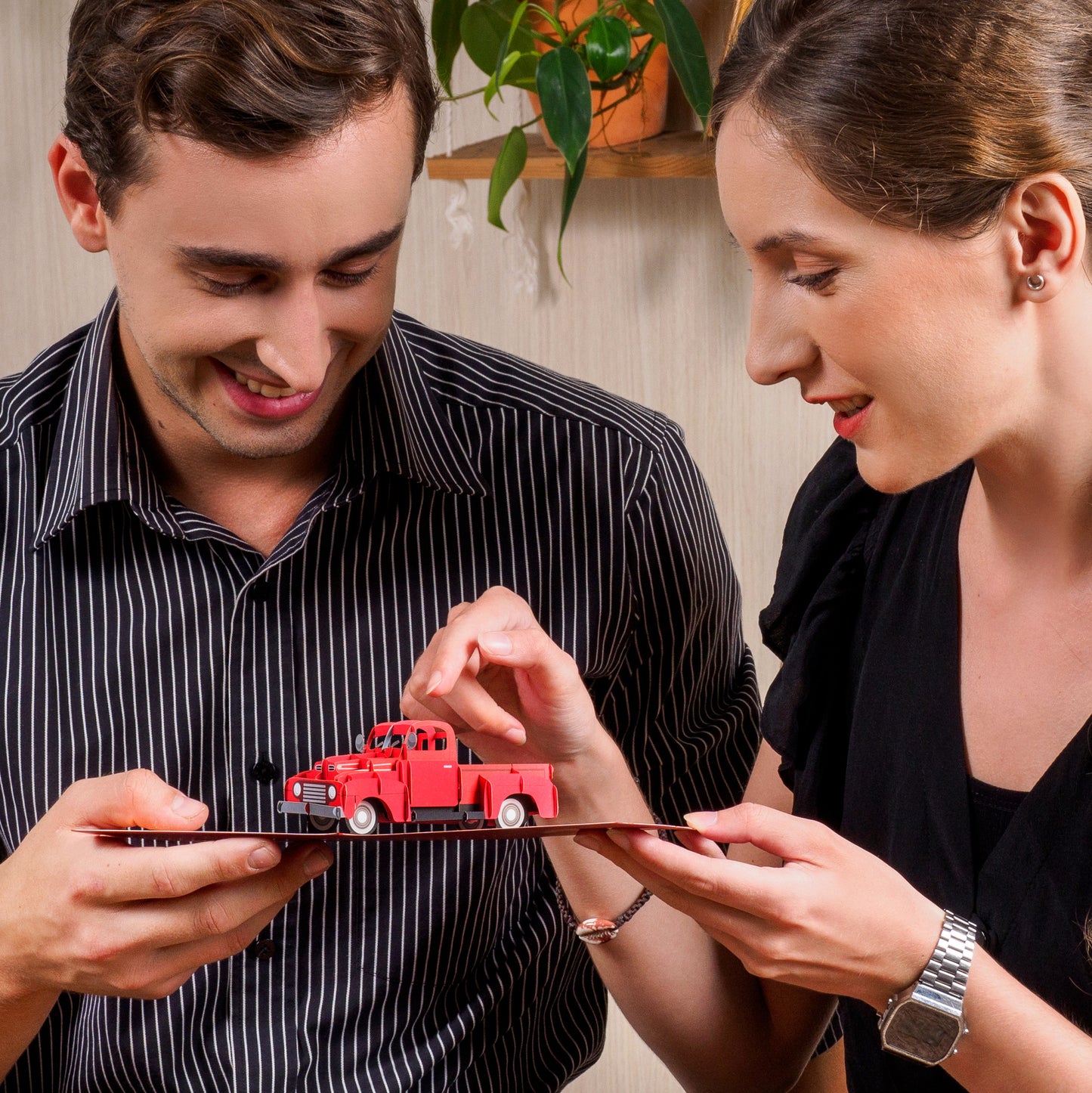 Close-up of two people admiring the 3D red truck in the Classic Truck Pop Up Card.