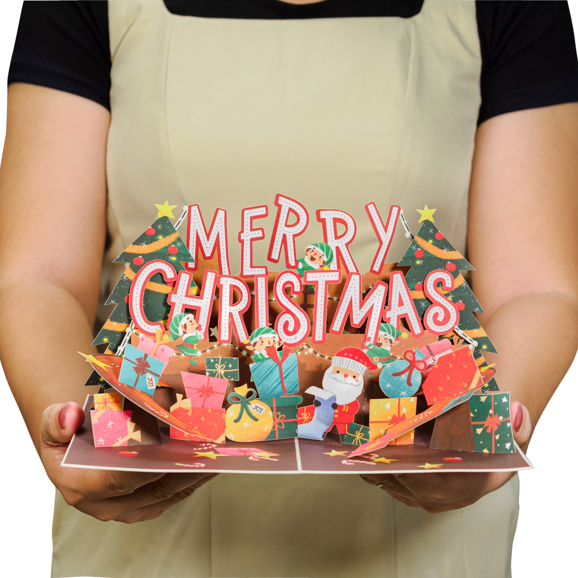 Person displaying a Merry Christmas pop-up card with festive decorations.