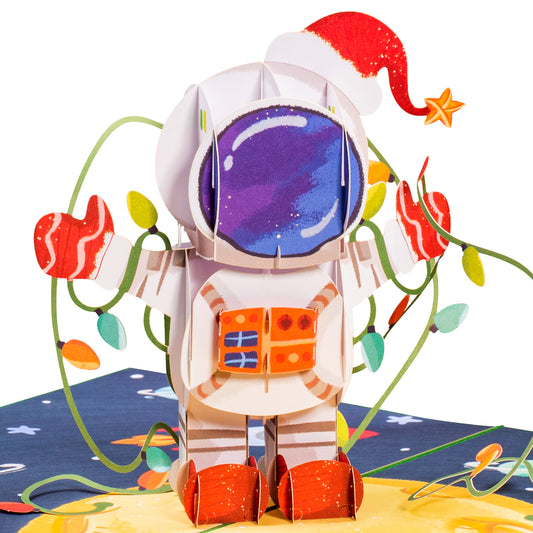 3D popup card featuring an astronaut in a Santa hat with festive lights.